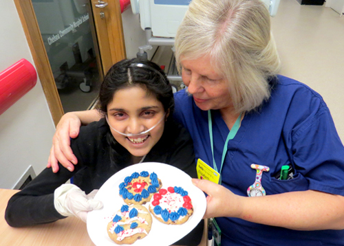 Ramandeep Kaur with a nurse and a plate of decorated cookies 