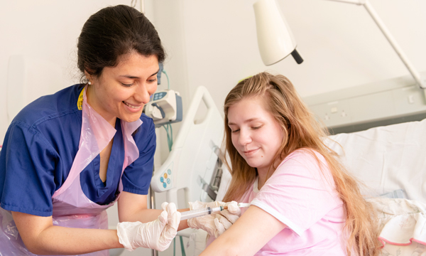 Nurse giving a teenage patient an injection