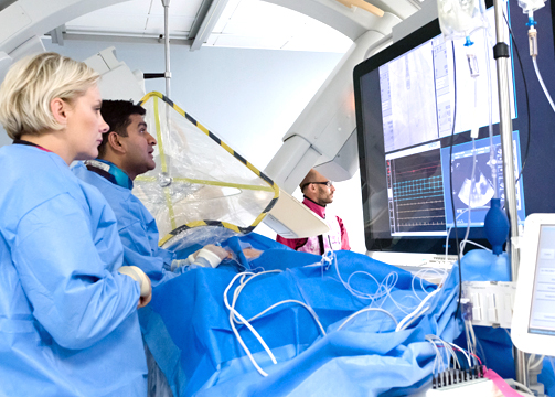 Consultant cardiologist Shouvik Haldar working alongside healthcare assistant Magda Greda in the catheter labs in Harefield Hospital